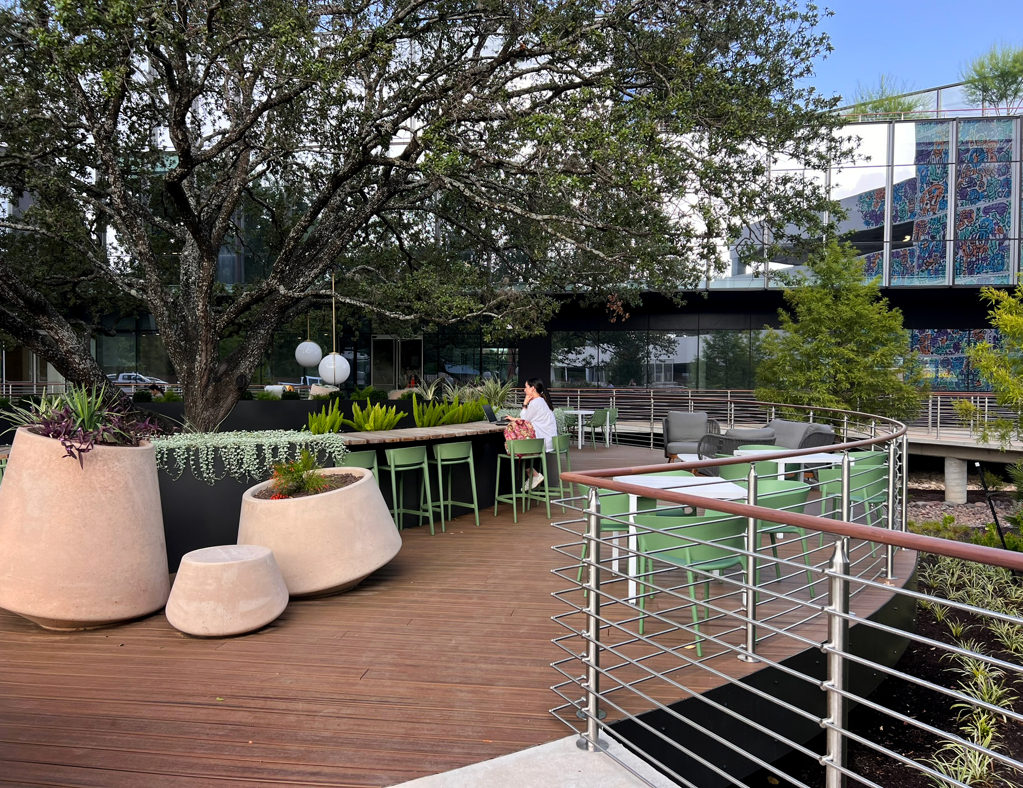 Cast planters and stools on the timber deck, the counter beyond