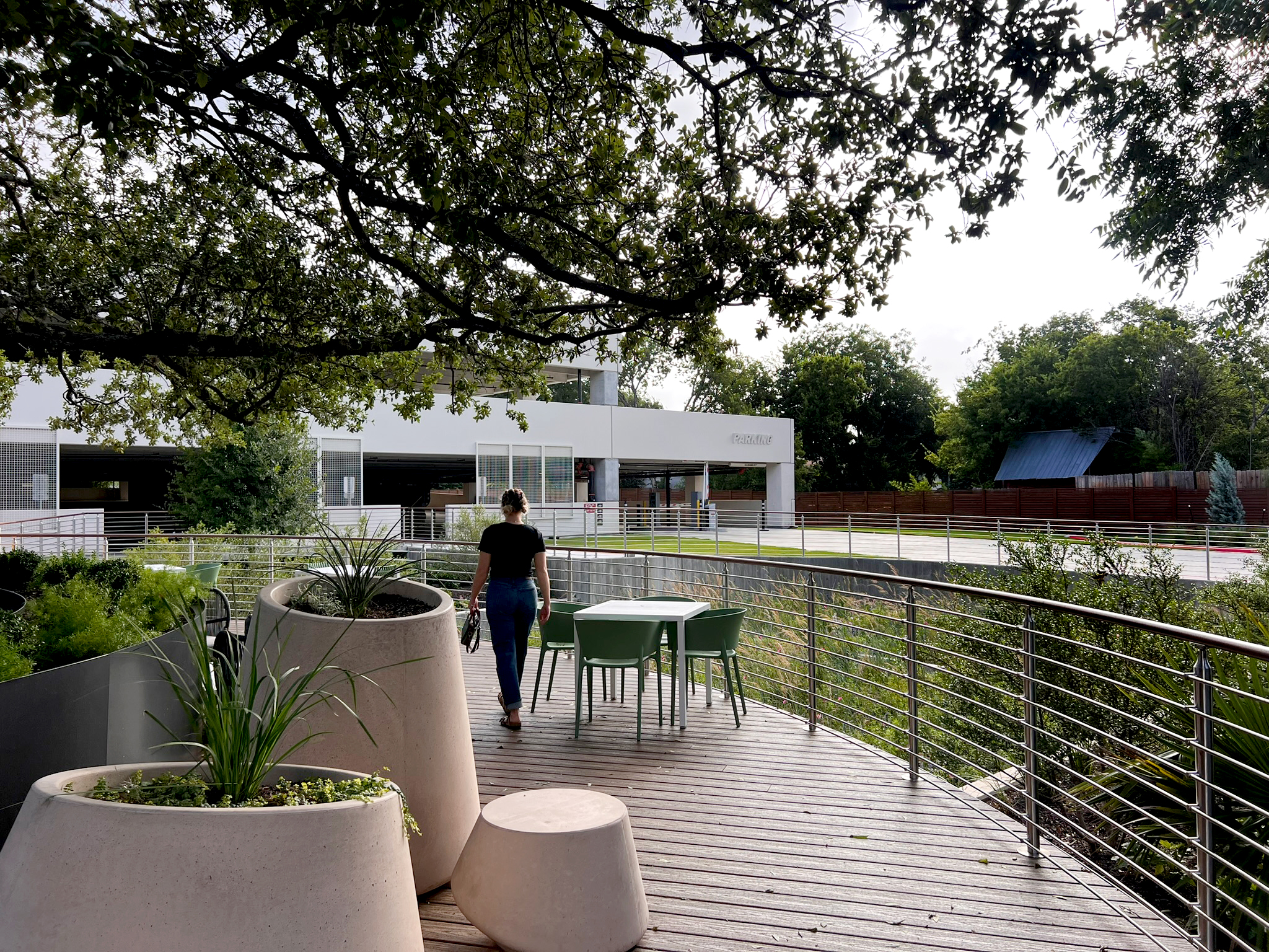 A walkway along the deck edge with cast planters and ornamental grasses