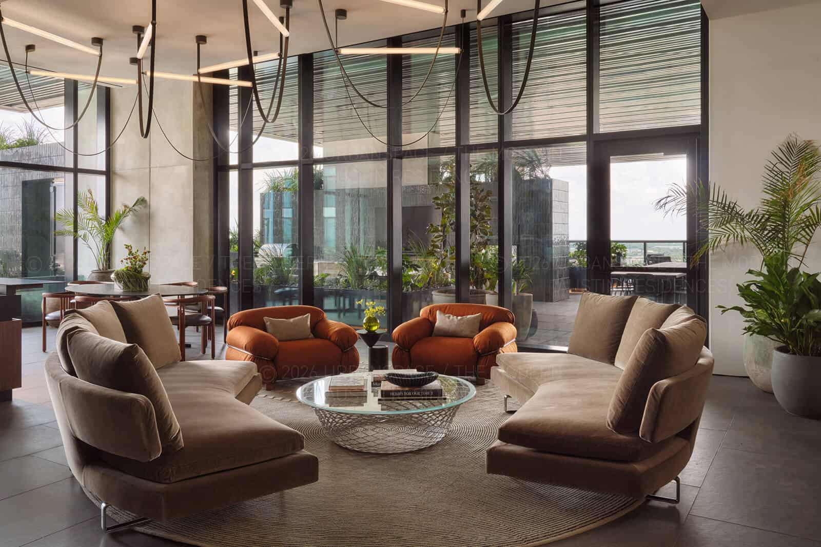 Sky lounge looking out through full-height glass to the planted terrace beyond