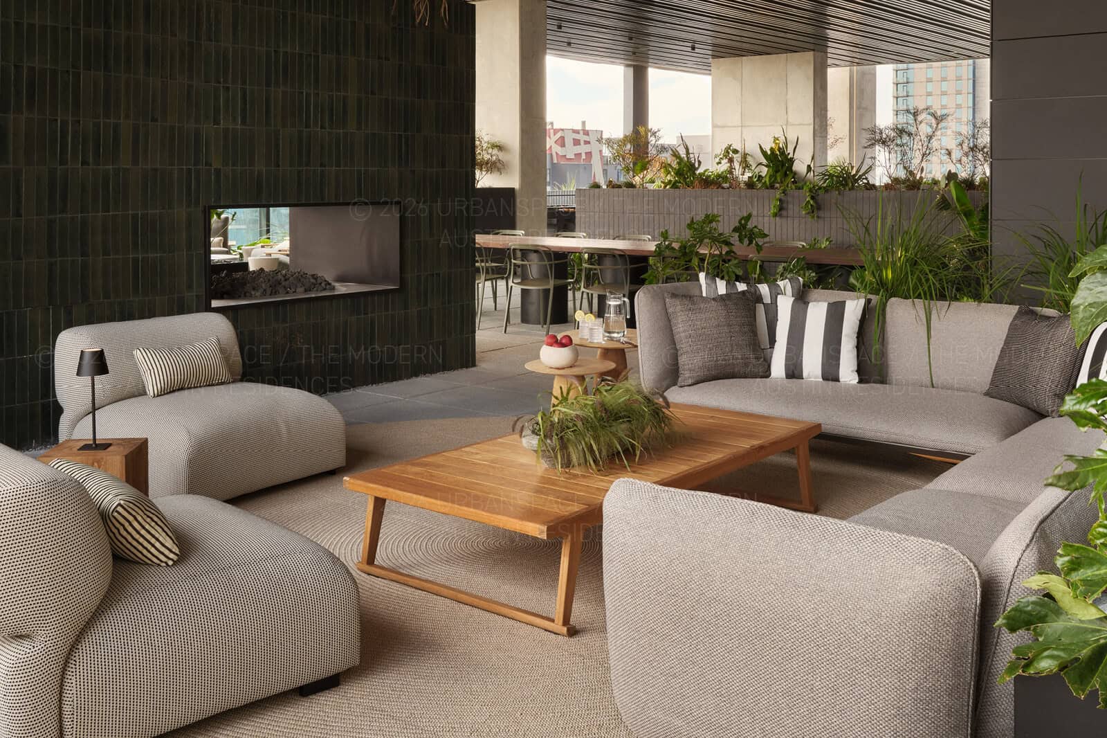 Terrace lounge with fireplace, grasses and philodendron enclosing the seating