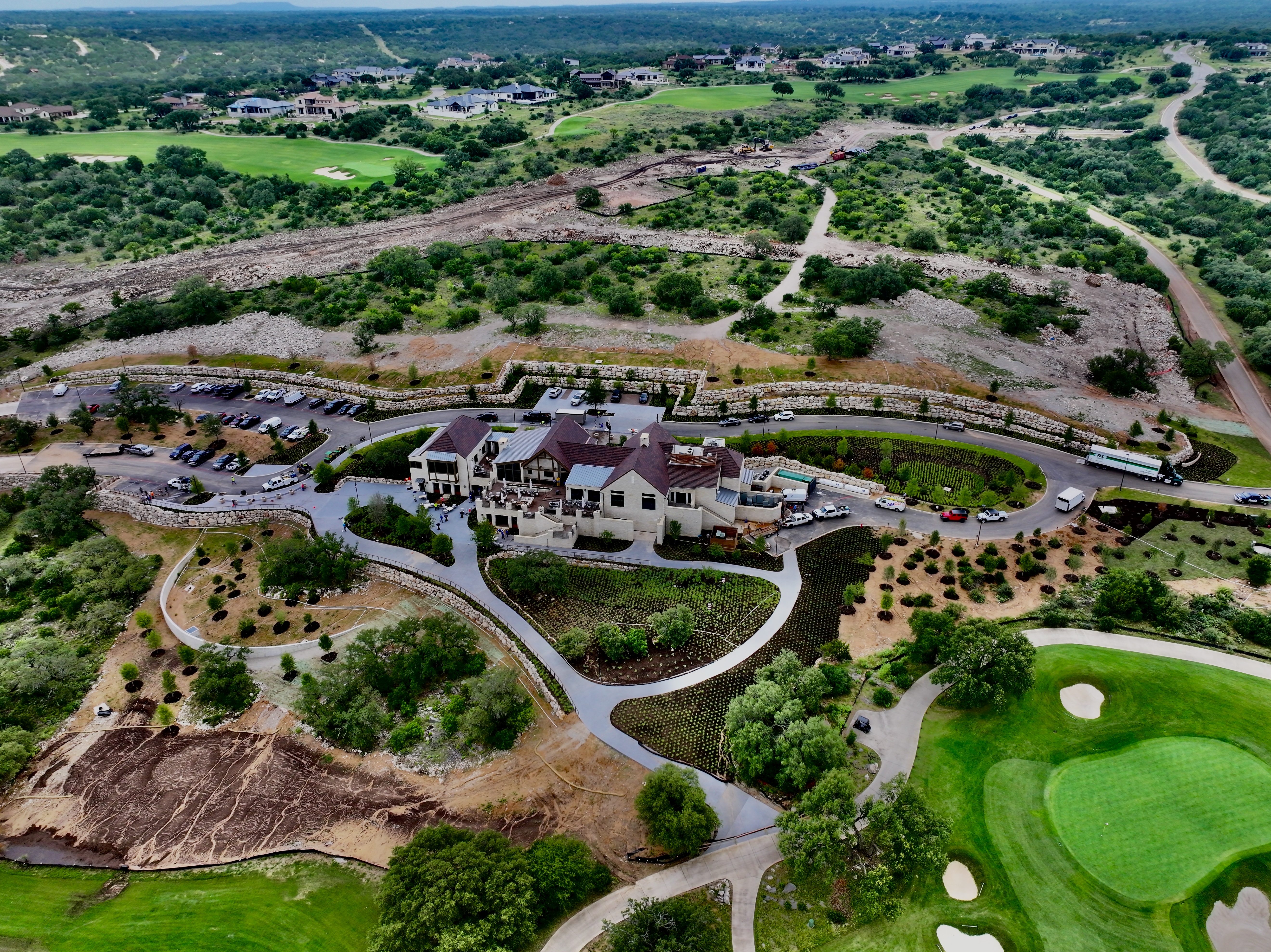 Summit Rock Clubhouse from the air — boulder terraces set between fairways and hill country scrub