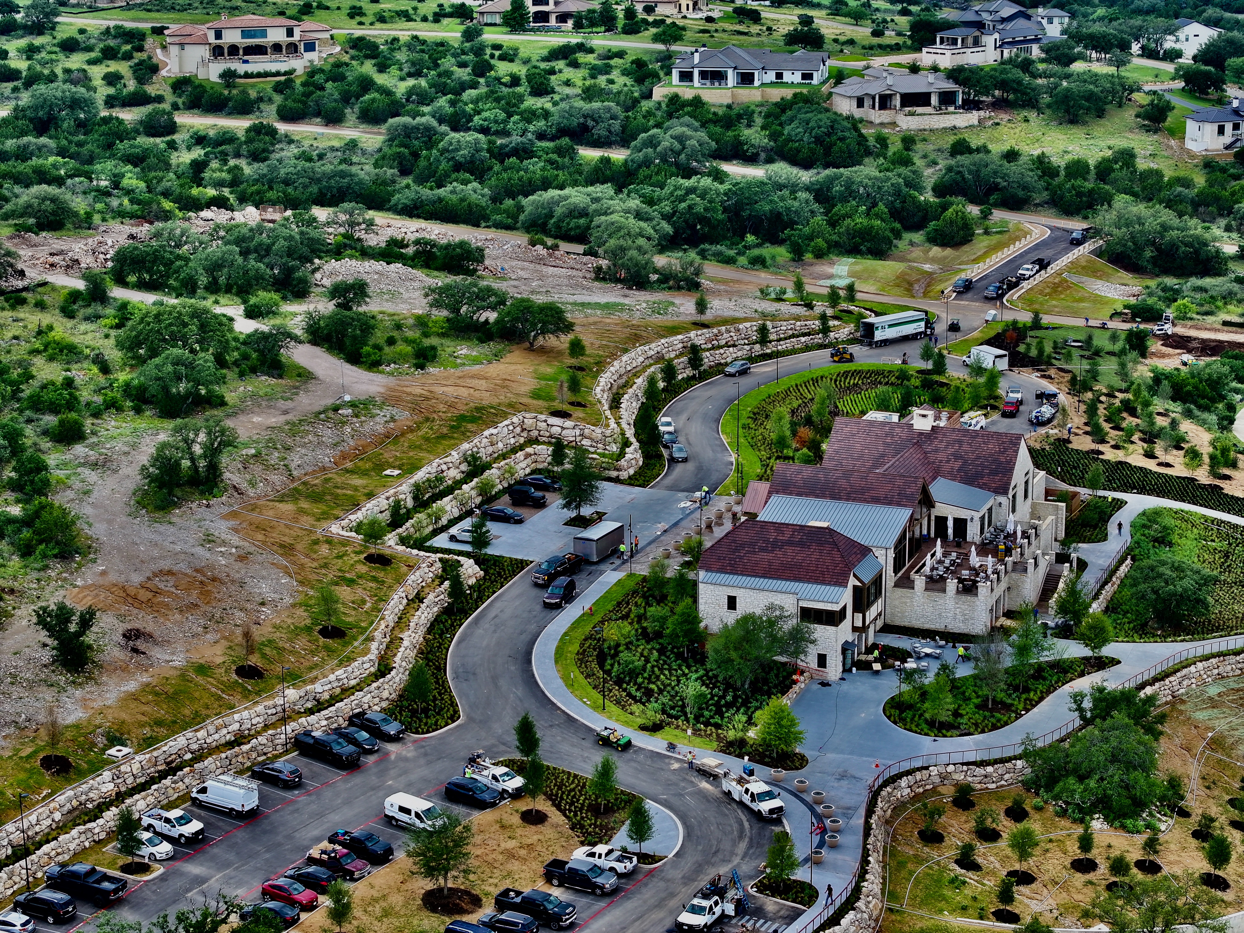 Oblique aerial showing the boulder retaining walls stepping around the arrival court and parking terraces